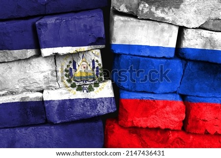 Concept of the relationship between El Salvador and Russia with two painted flags on a damaged brick wall
