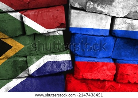 Concept of the relationship between South Africa and Russia with two painted flags on a damaged brick wall