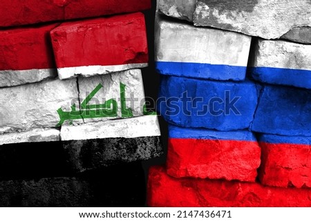 Concept of the relationship between Iraq and Russia with two painted flags on a damaged brick wall