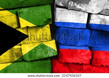 Concept of the relationship between Jamaica and Russia with two painted flags on a damaged brick wall