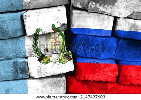 Concept of the relationship between Guatemala and Russia with two painted flags on a damaged brick wall