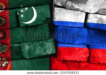 Concept of the relationship between Turkmenistan and Russia with two painted flags on a damaged brick wall