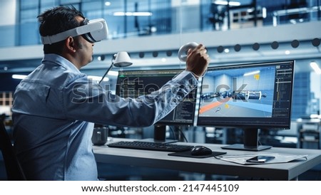 Automotive Engineer Using a VR Software to Work on Electric Motor and Vehicle Platform in Interactive Environment in a Factory Office. Industrial Engineer Using Headset and Controllers. Royalty-Free Stock Photo #2147445109