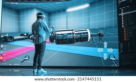 Automotive Engineer Making Presentation of a Modern VR Software Testing and Developing Vehicle Platforms. Engineer Uses Headset and Controllers to Showcase Functionality on a Big Screen on Stage. Royalty-Free Stock Photo #2147445151