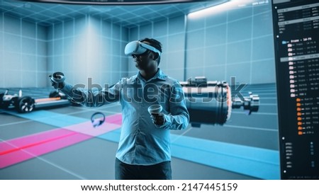 Automotive Engineer Using a VR Software to Showcase Electric Motor and Vehicle Platform in Interactive Environment. Multiethnic Engineer Using Virtual Reality Headset and Controllers for His Project. Royalty-Free Stock Photo #2147445159