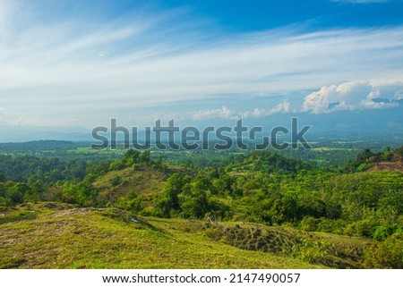 An aerial photo of a hill with green and shady trees, in the province of Aceh, Indonesia.