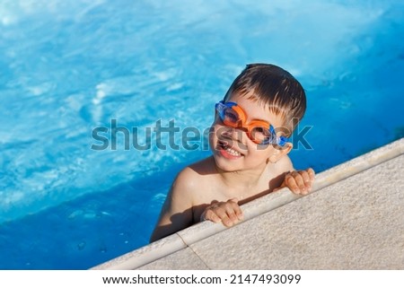 happy little boy in swimming goggles in the pool on resort Royalty-Free Stock Photo #2147493099