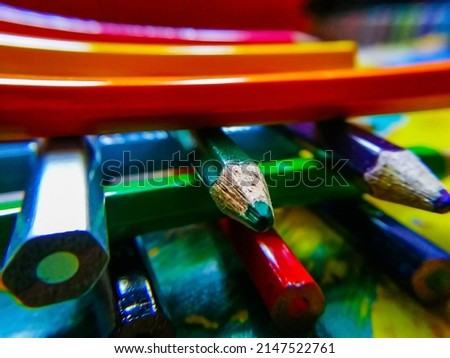 Stock photo of color pencil crayons arranged one over the other on colorful background. Picture captured at bangalore, Karnataka, India. focus on object.