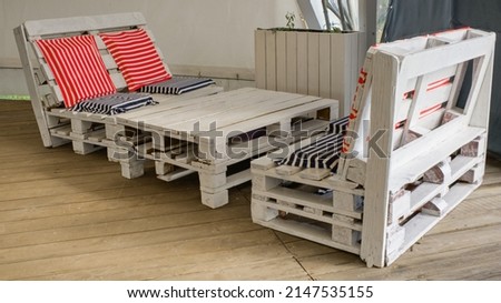 A set of garden furniture made from used pallets in an elegant nautical style. Concept of reuse, upcycling, modern summer beach holiday. Royalty-Free Stock Photo #2147535155