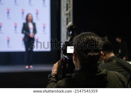 Asian man Videographer in backside are shooing and recording video in Speech event on the stage.