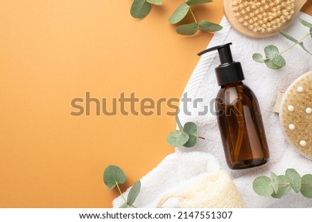 Natural cosmetics concept. Top view photo of glass dispenser bottle anti-cellulite washcloth towel and eucalyptus on isolated beige background with empty space