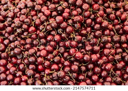 Close up of pile of ripe cherries with stalks and no leaves. Big collection of fresh red cherries. Ripe cherries background. Royalty-Free Stock Photo #2147574711