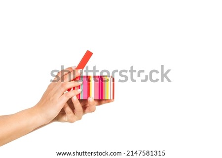 Woman hand holding an open colored box on a white background with copy space