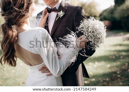 groom hugging his bride by the waist Royalty-Free Stock Photo #2147584249