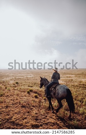 Woman riding on a horse during sunrise. 