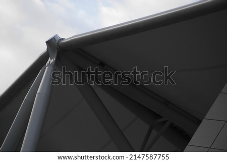 Abstract architecture of modern public or office building. Hi-tech roof structure with girders. Close-up photo of industrial or business real estate. Polygonal geometric backgrouund with triangles.