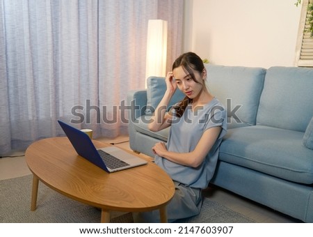 smiling Asian woman using the laptop at home at night