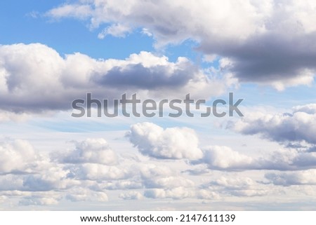 Blue sky with beautiful white many fluffy cumulus clouds in sunlight background texture