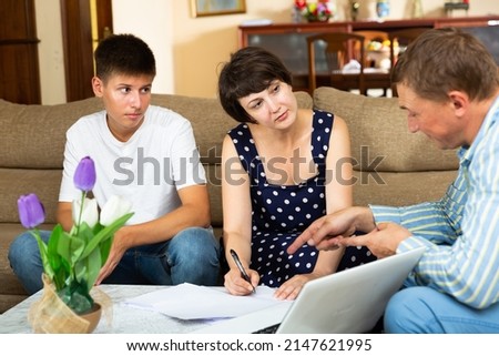 Mother and teen son with bank employee at home. High quality photo