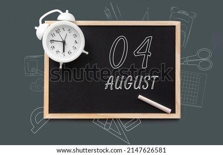 august 4. 4th day of month, calendar date.   Blackboard with piece of chalk and white alarm clock on green background. Concept of day of year, time planner, summer month.