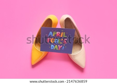 Female shoes and card with text APRIL FOOL'S DAY on pink background