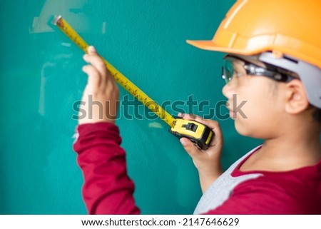 Asian boy dressed as a craftsman and holding tools