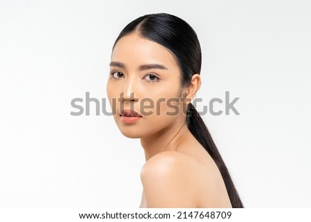 Beauty shot of pretty young Asian woman with clean face skin looking at camera during spa session against white background Royalty-Free Stock Photo #2147648709