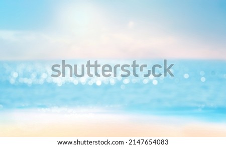 Abstract blur defocused background, nature of tropical summer beach with rays of sun light. Golden sand beach, sea water against blue sky with white clouds. Copy space, summer vacation concept.