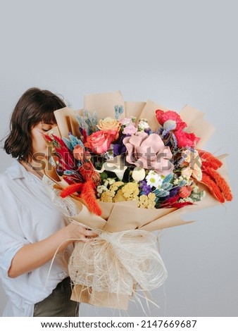Young woman with a gift bouquet of fine peach roses, mono bouquet of roses. Peony roses flowers. Young man holding fresh bouquet of peony roses.