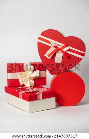 Red and striped boxes with gifts tied bows on white background