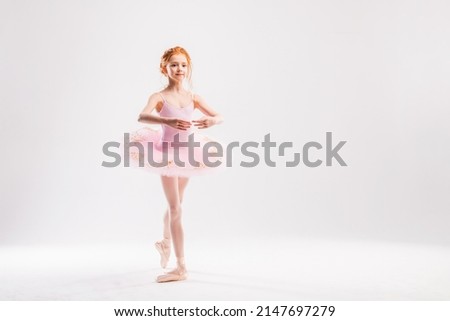 Little ballerina dancer in a pink tutu academy student posing on white background Royalty-Free Stock Photo #2147697279