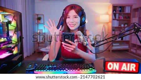 asian female cybersport gamer have live stream with on air light sign and playing mobile game by the smartphone at home Royalty-Free Stock Photo #2147702621