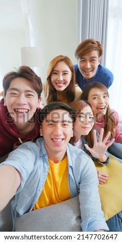point of view happy asian friends having video chat streaming together in room on sofa with smartphone