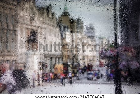 View of the streets of the historic part of Cambridge through the glass of a car covered with raindrops. Focus on drops