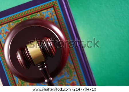 Sharia or Islamic law concept with gavel and koran on green background                               