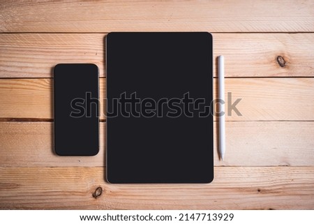 Blank screen tablet and smartphone with pencil isolated on wooden background. Online working concept.
