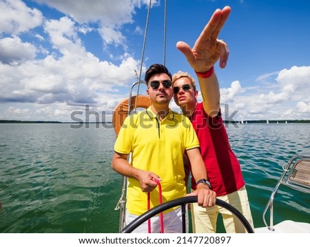 young person point forward his hand to his friend the direction of sailing on sailing yacht. summer vacations on sailing yacht Royalty-Free Stock Photo #2147720897
