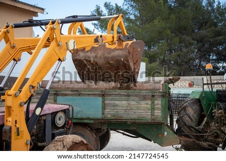 Mechanical shovel emptying debris onto tractor trailer
