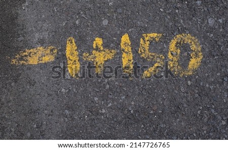 Black gravel pavement with yellow painted numbers background texture