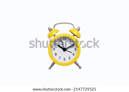 Yellow old-fashioned alarm clock with a dial on a white background with free space for text. The concept of punctuality or routine. Vintage alarm clock from the past