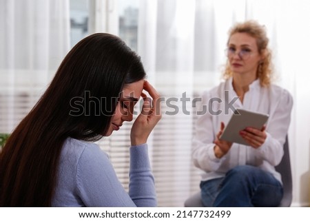 Young woman in distress on a psychological therapy session. A conversation between psychologist and her client in the office. Copy space, background. Royalty-Free Stock Photo #2147732499