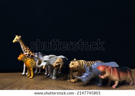 Group of jungle animals toys isolated over black background. Plastic animals toys. Protection of the animal. Children's toy.