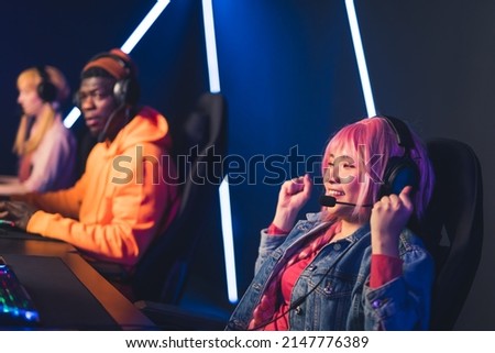 pink-haired girl celebrating win in video games medium closeup indoors game industry. High quality photo