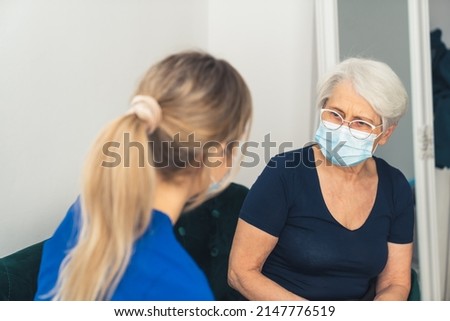 senior woman talking to her home care specialist at home medium closeup living room healthcare concept . High quality photo