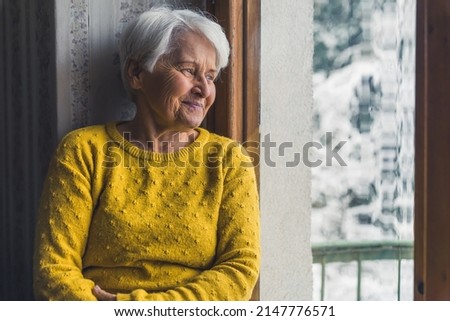 nice European senior woman looking youth from the window medium shot indoors senior people support concept. High quality photo