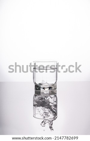 A splash of water in a glass on a light background