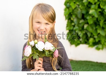 Photo of cheerful sweet cute little caucasian lady hands hold present bouquet fresh natural flowers outdoors.