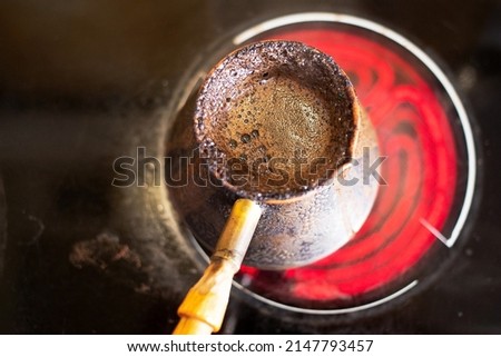 invigorating coffee in an old Turkish pot on a hot stove on a bright spring morning is prepared and infused.