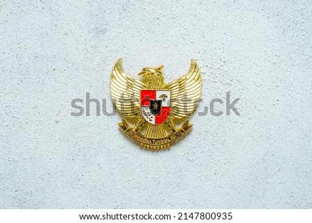 Hand holding Garuda Pancasila emblem Isolated on white background. Indonesia independence day 17th August, pancasila day concept.  Royalty-Free Stock Photo #2147800935