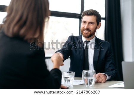 Shaking hands, making deal, agreements. Caucasian influential attractive successful businessman, development boss, ceo company, shakes hands with female colleague in modern office, smile at each other Royalty-Free Stock Photo #2147806209